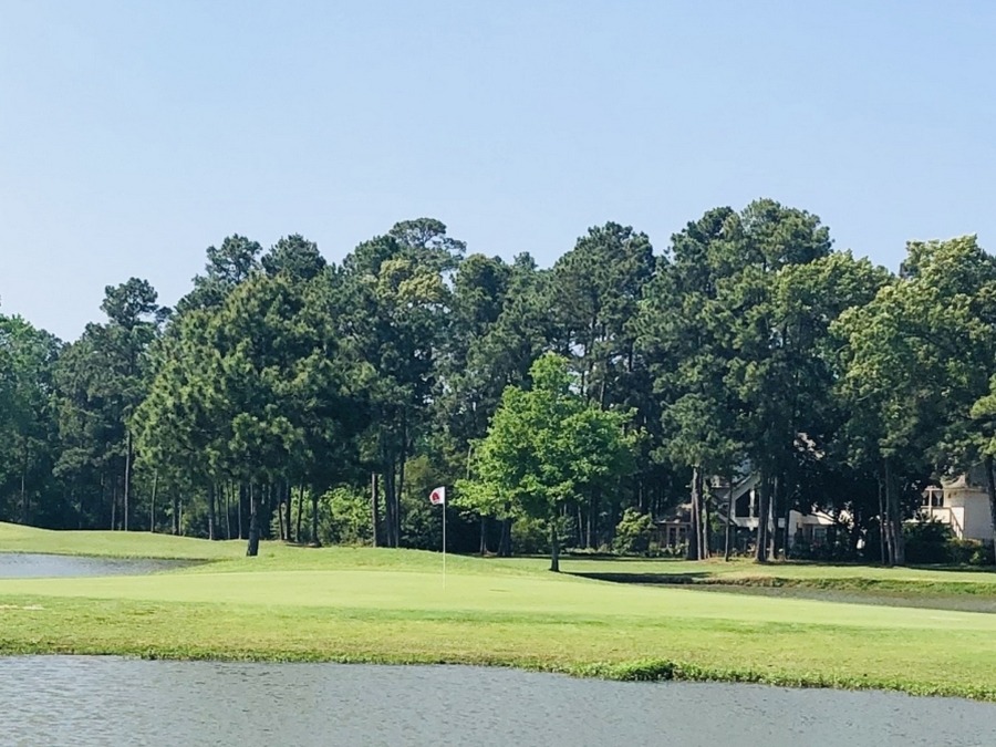 Lake surrounding a green.