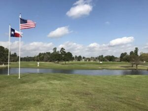 USA and Texas flags fly over the course and water.