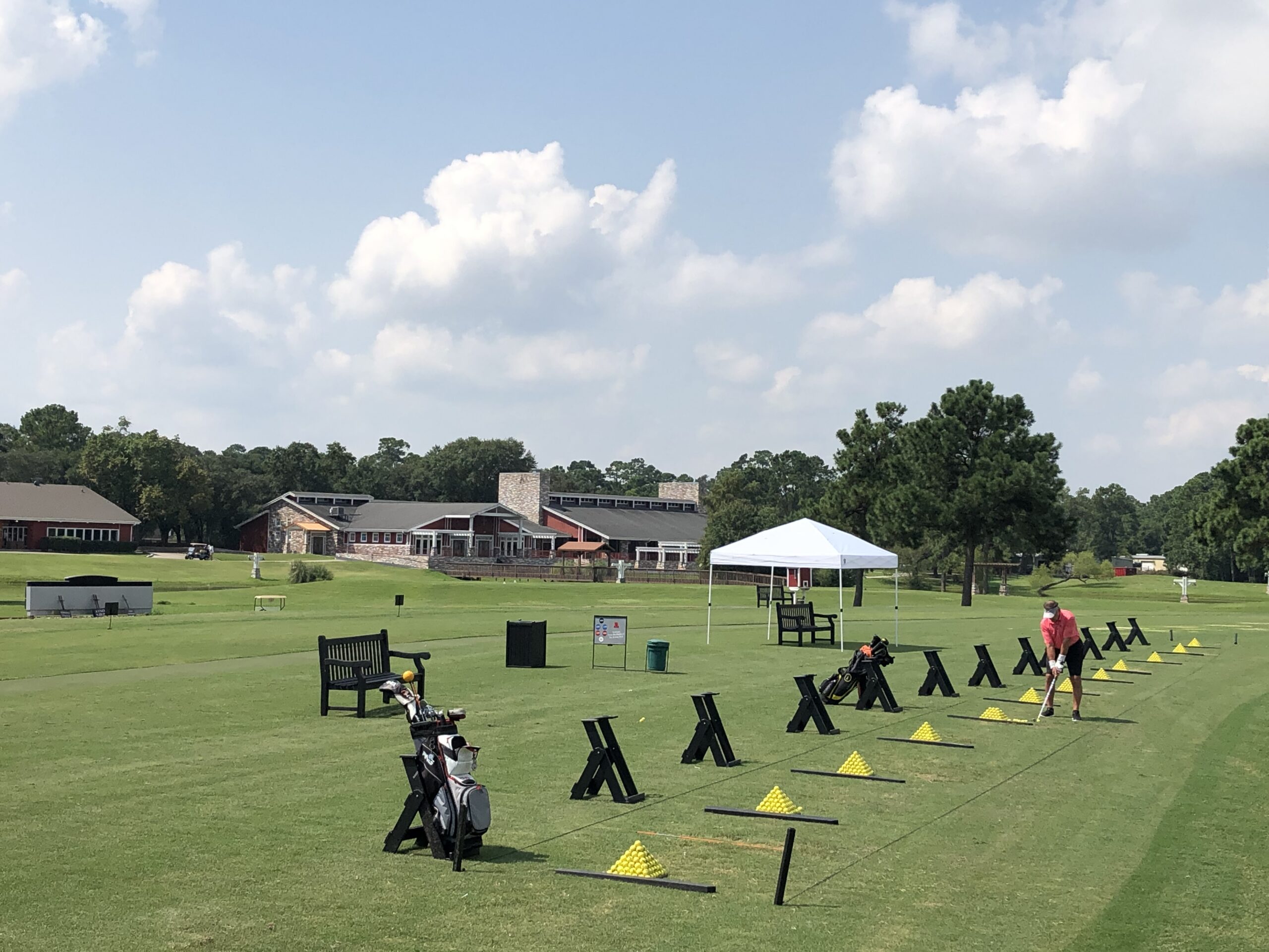 View of the driving range featuring a row of stands and accompanying pyramids of golf balls, ready to hit.